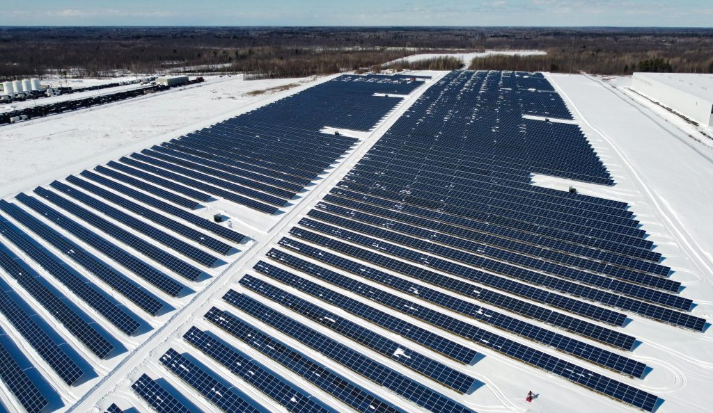 A drone-captured image of a large solar farm in Kingston, Canada, surrounded by snow.